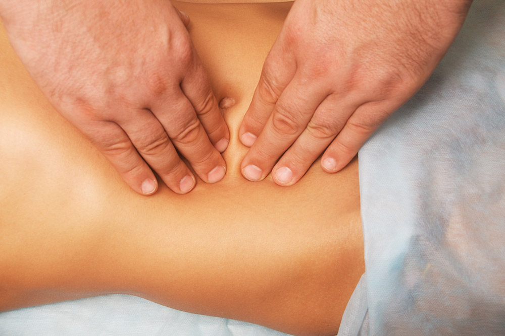 Female Patient at the physiotherapy doing physical exercises with her therapist, he gives her a medical massage