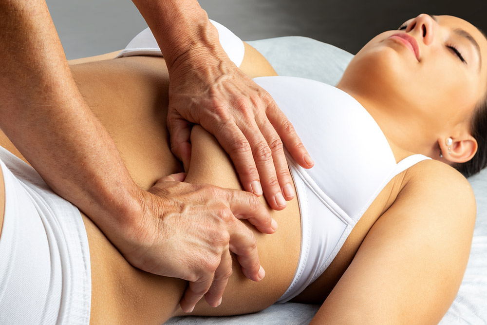 Female Patient at the physiotherapy doing physical exercises with her therapist, he gives her a medical massage